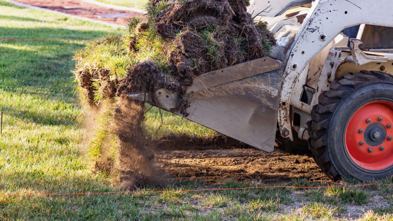 Small Bulldozer Removing Grass From Yard Preparing For Pool Installation