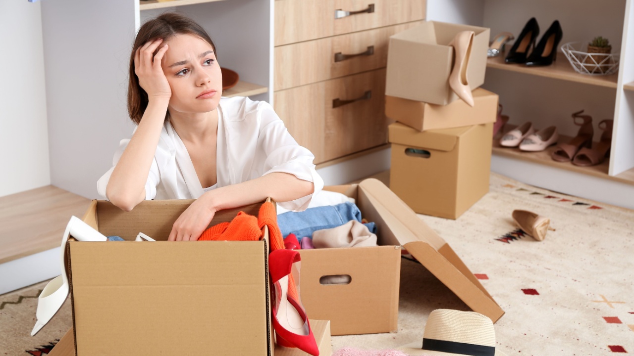 Upset young woman with wardrobe box in dressing room