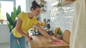 Attractive young woman tidying up the domestic kitchen and smiling