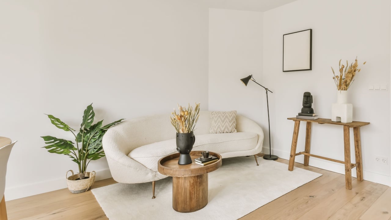 a living room with white walls and hardwood flooring the room is decorated in neutral tones, including light wood floors