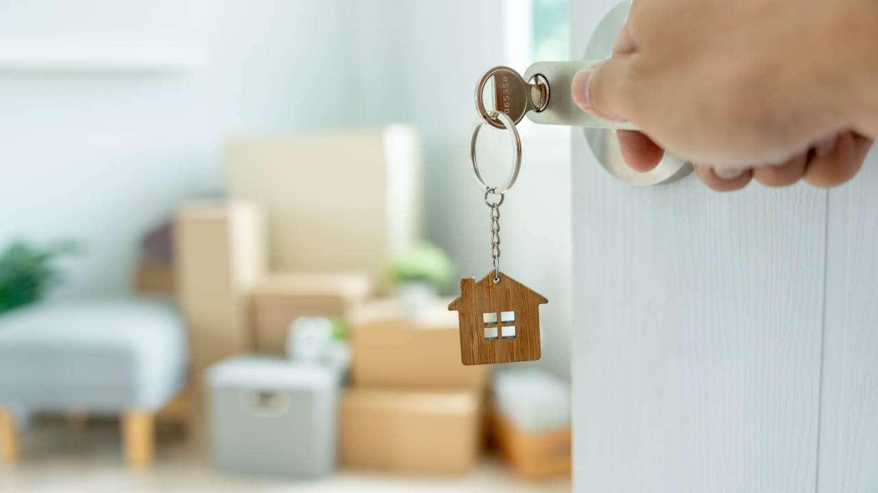 Moving house, relocation. The key was inserted into the door of the new house, inside the room was a cardboard box containing personal belongings and furniture. move in the apartment or condominium
