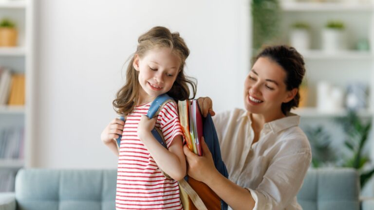 Happy family preparing for school. Little girl with mother.