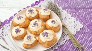 eclairs with lavender custard cream on wooden background