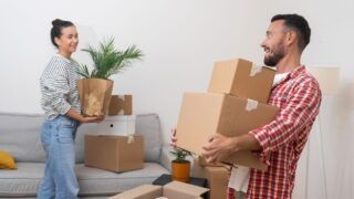 Young husband and wife collect parcels with things for moving living in new apartment in countryside collecting various home decorations in packing boxes