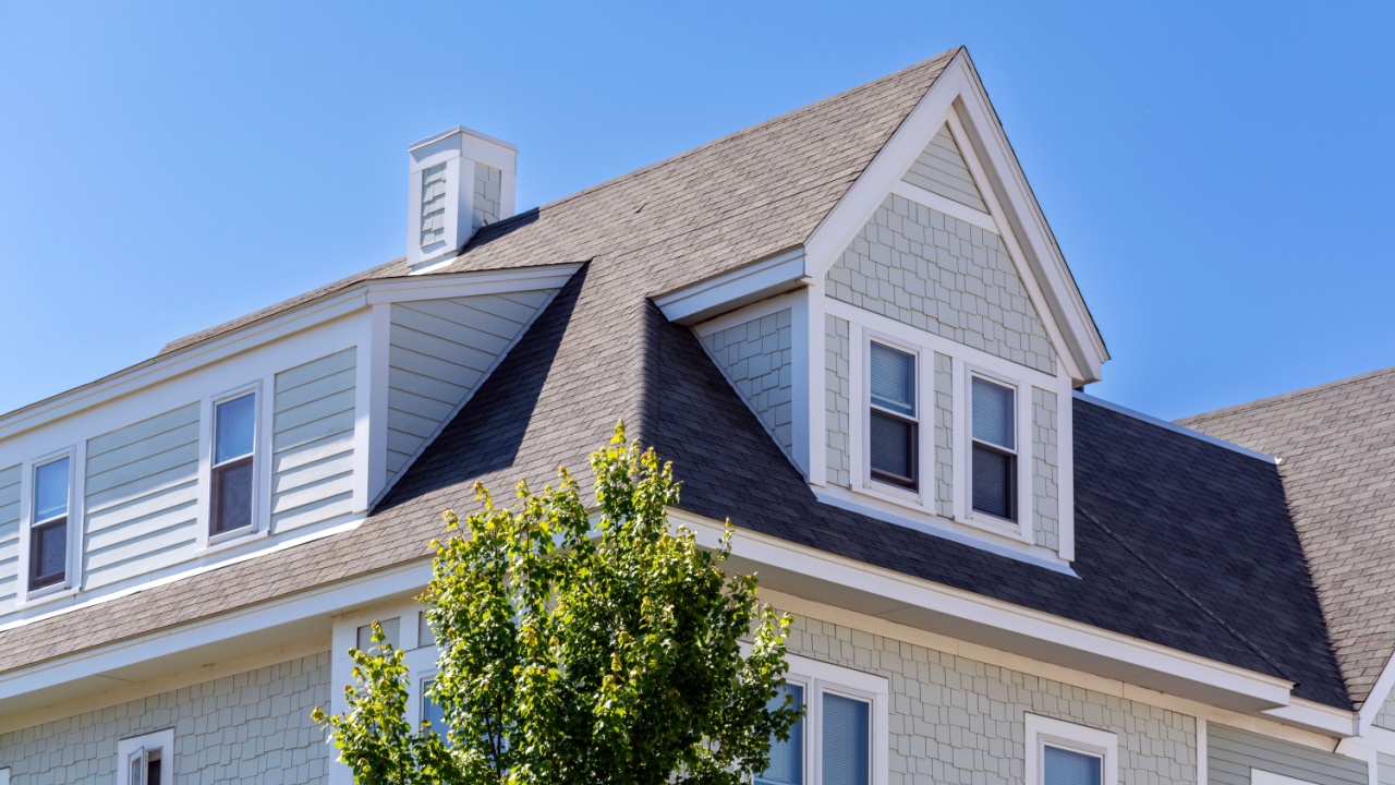 Dormer windows on the sloped shingle roof of a newly built house in Brighton, Massachusetts, USA