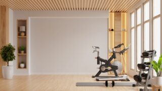 Interior of modern light gym is well-equipped with modern machines and fitness gear