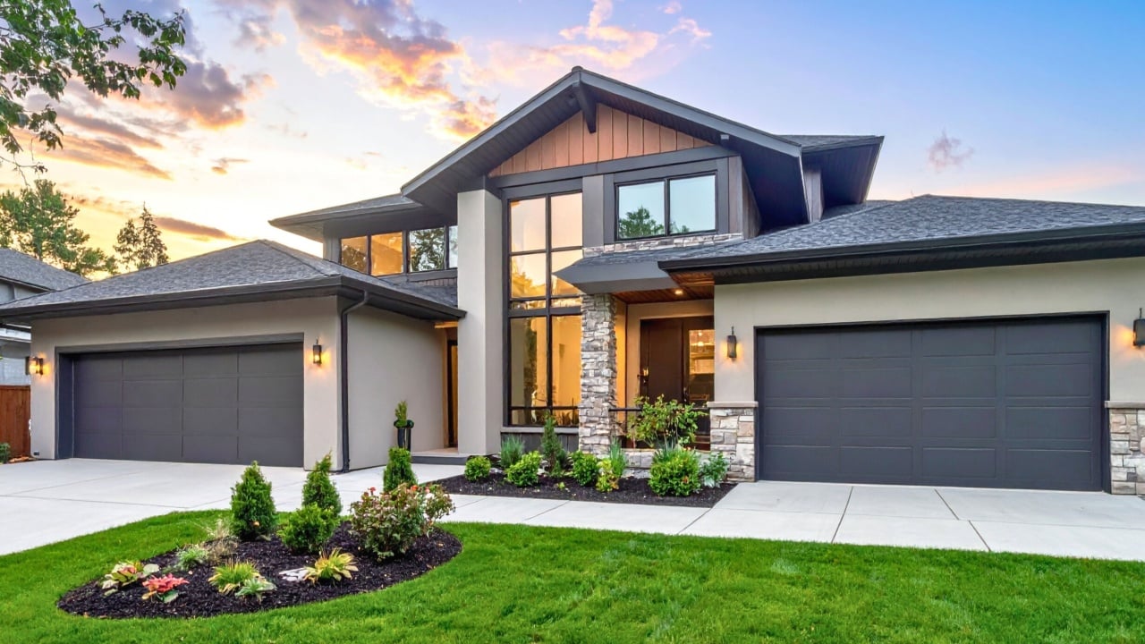 Modern luxury two story house with large garage and mountain view backdrop