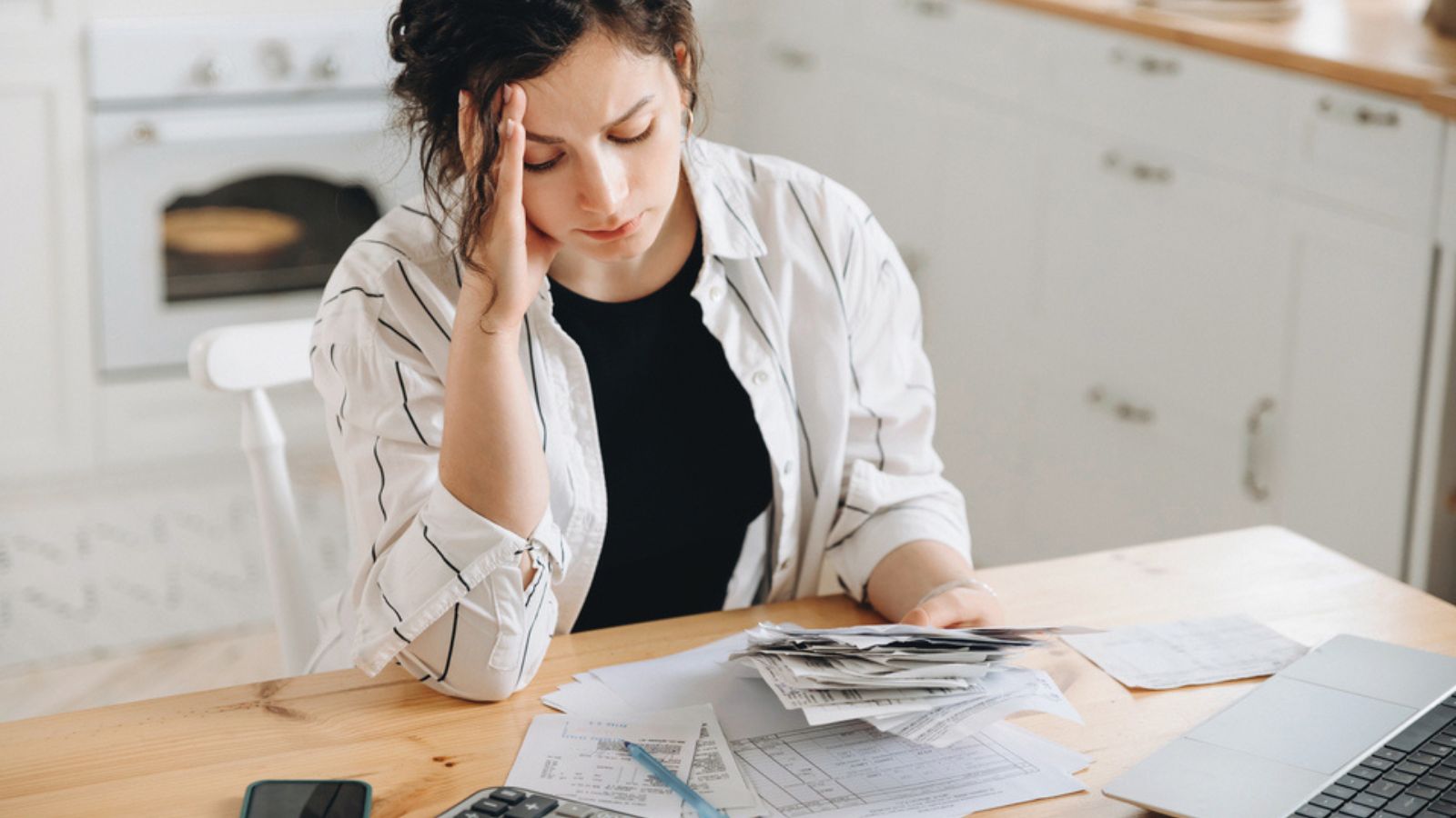 Stressed caucasian woman trying to deal with financial documents, having problem to find money to pay utility bills or loans