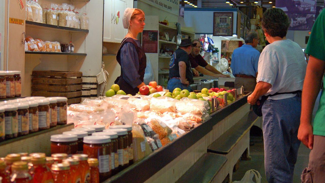  A Mennonite woman minds an organic food stall in Lancaster, Pennsylvania
