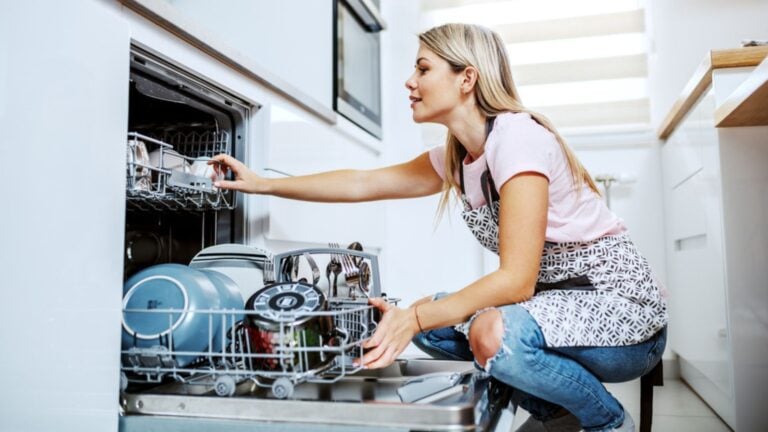 Woman Loading plates Dishwasher In Kitchen (1)
