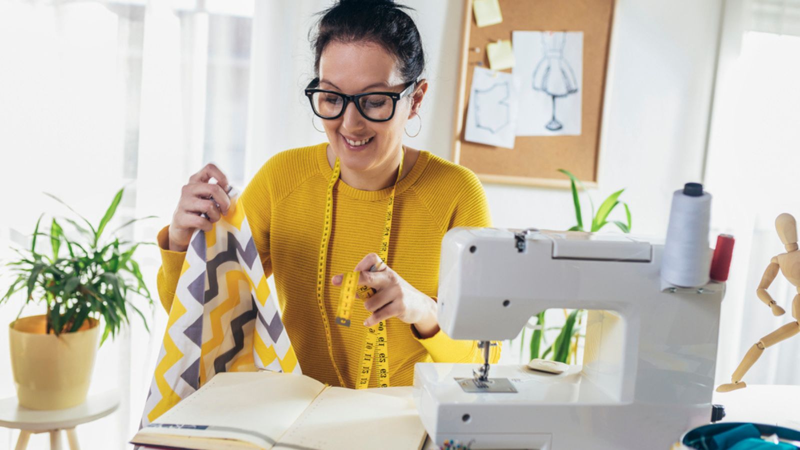 Woman sewing on a sewing machine at her home. Woman seamstress work on the sewing-machine