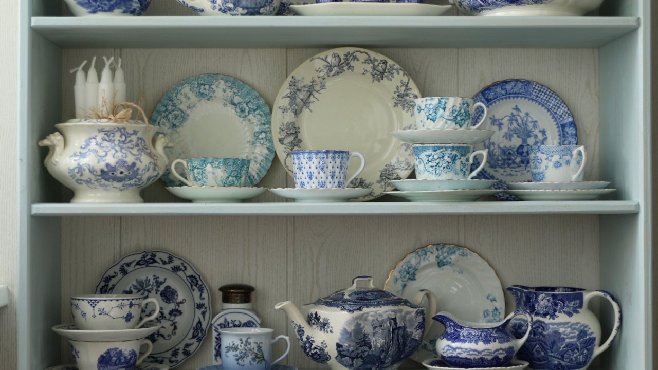 Home Collection of antique, vintage dishes, tableware, dinnerware, kitchen utensils with patina and craquelure, very old on wooden shelf, daylight, floral pattern