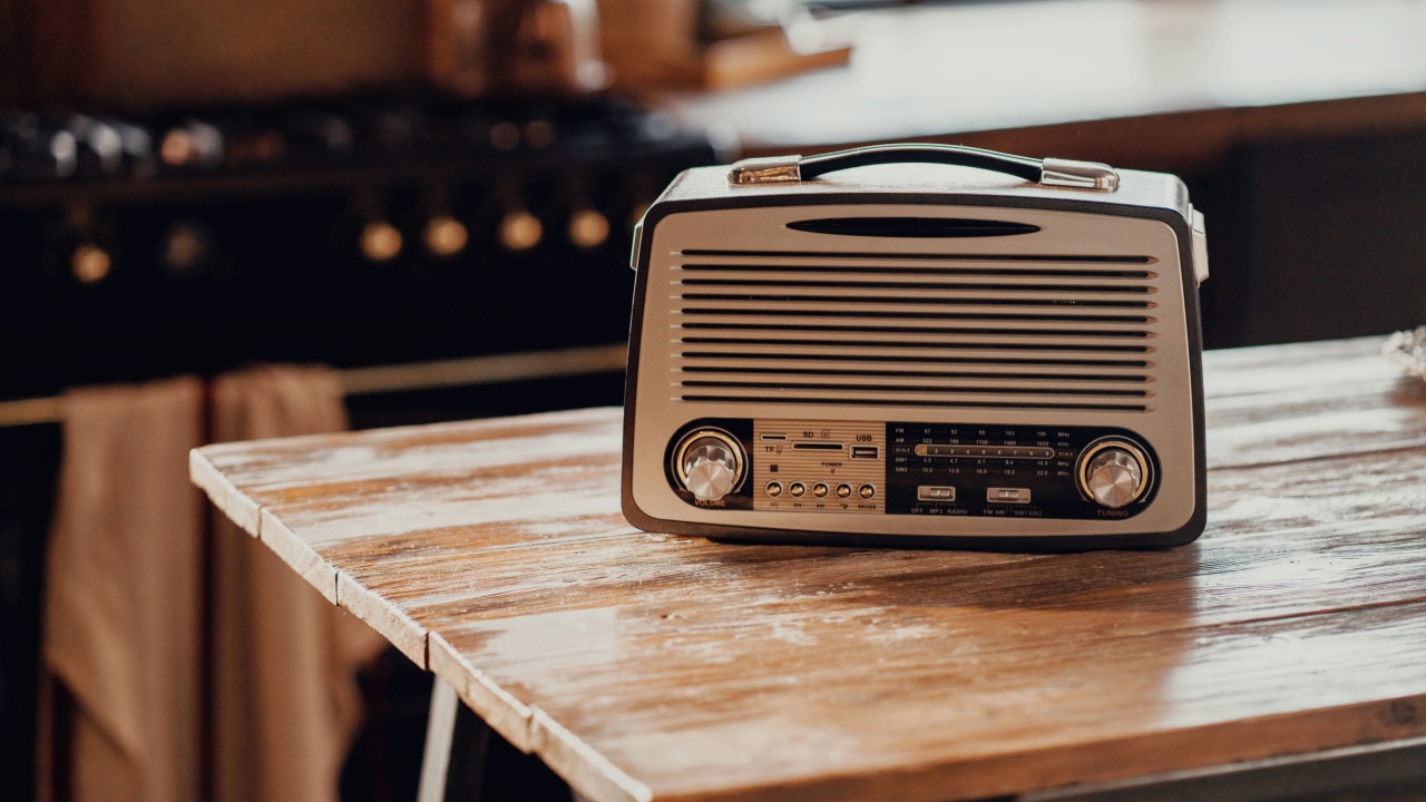an old vintage radio receiver sits on a wooden table. stylish old kitchen morning in the village and daylight from the window.