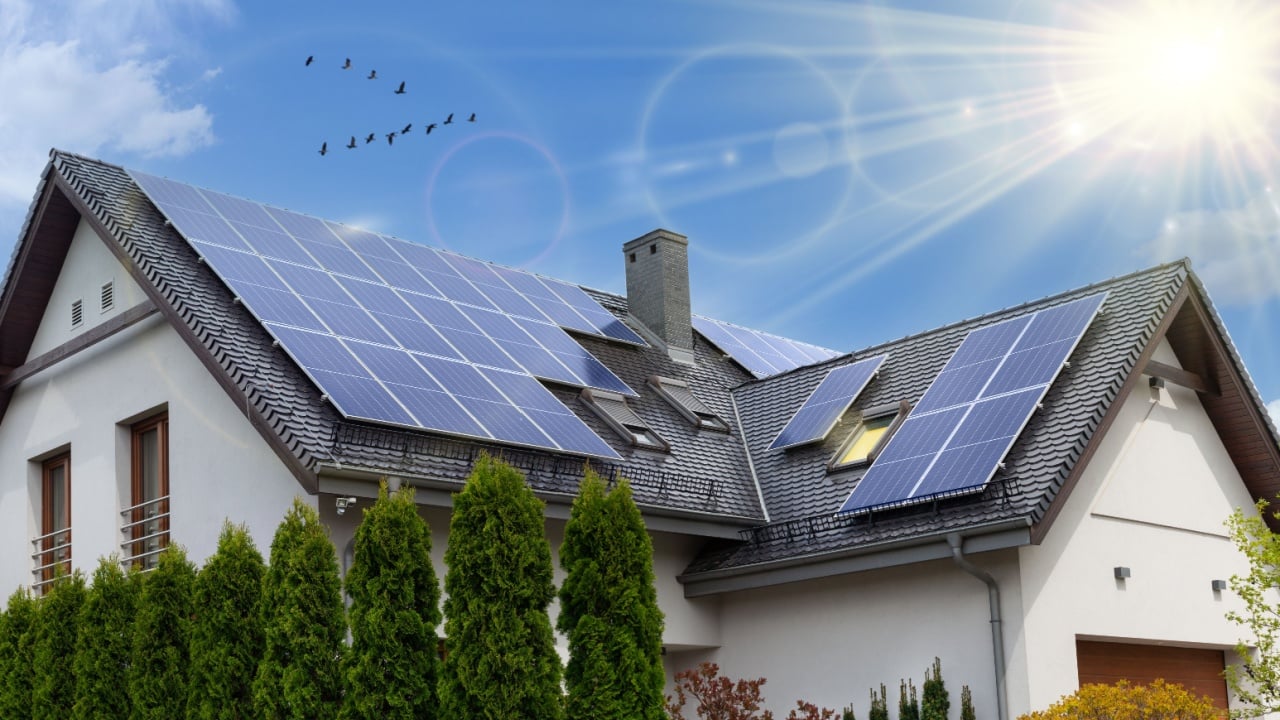 Solar panels on a gable roof. Beautiful, large modern house and solar energy. Rays of the sun.