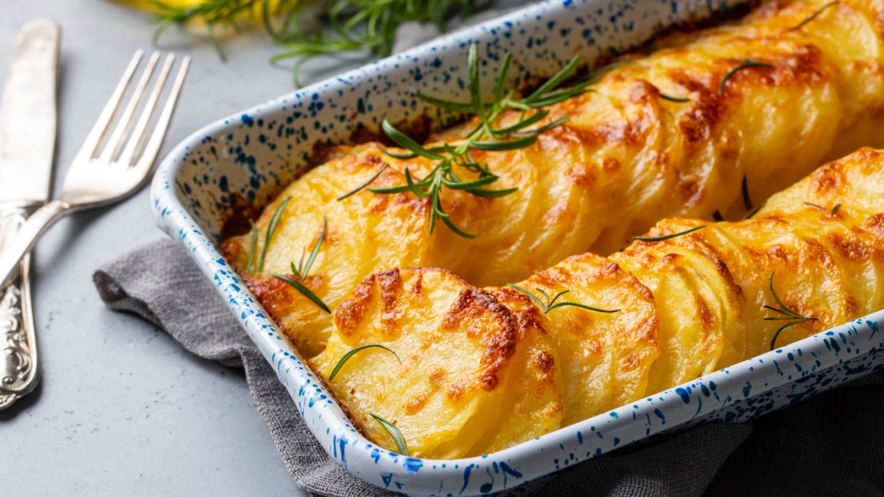 Potato gratin - graten (baked potatoes with cream and cheese) with rosemary and forks (Turkish name; Kremali patates)