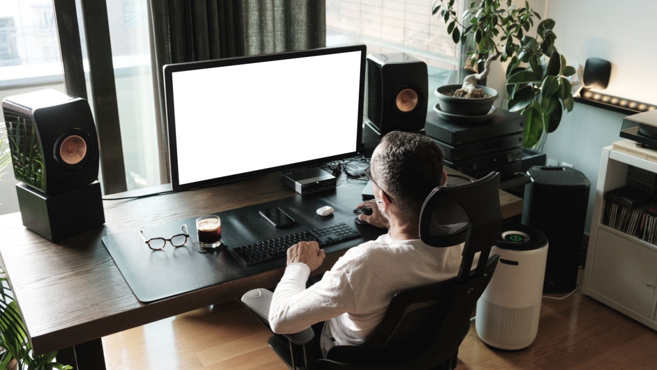 Middle age man working on computer at home, white screen mockup.