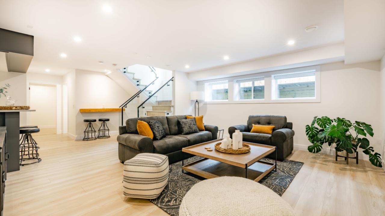 recreation party room with bar stairs with glass rails downstairs basement interior room with movie screen large grey sofa bohemian style