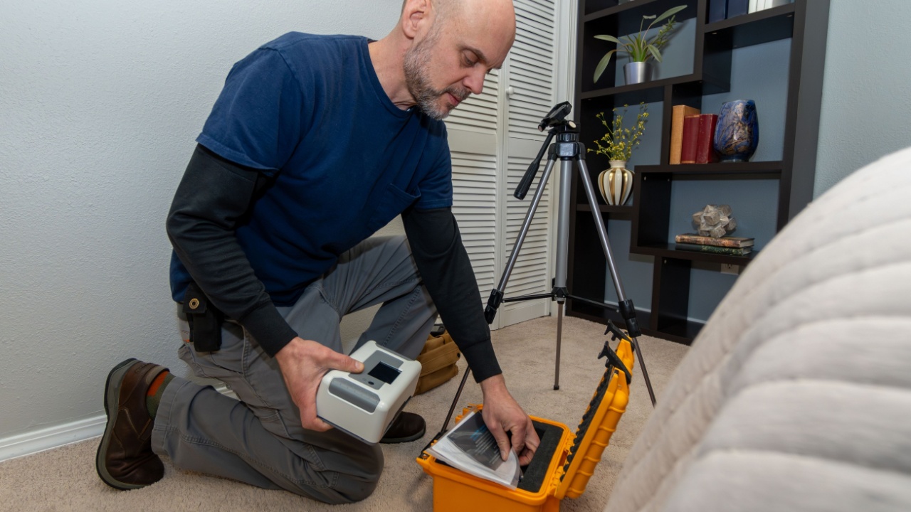 Home inspector doing a radon test setup in the lowest bedroom of a home.