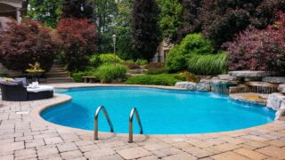 Dive into luxury with this stunning photo featuring a lavish swimming pool, exquisite house, lush green backyard, and meticulously designed garden. Experience the pinnacle of opulence and tranquility.