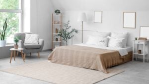 Cozy bed with white pillows in interior of light bedroom