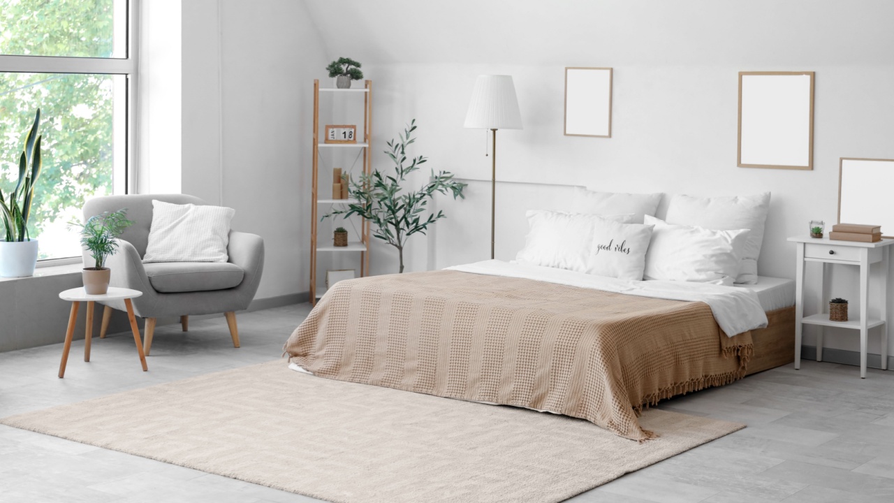 Cozy bed with white pillows in interior of light bedroom