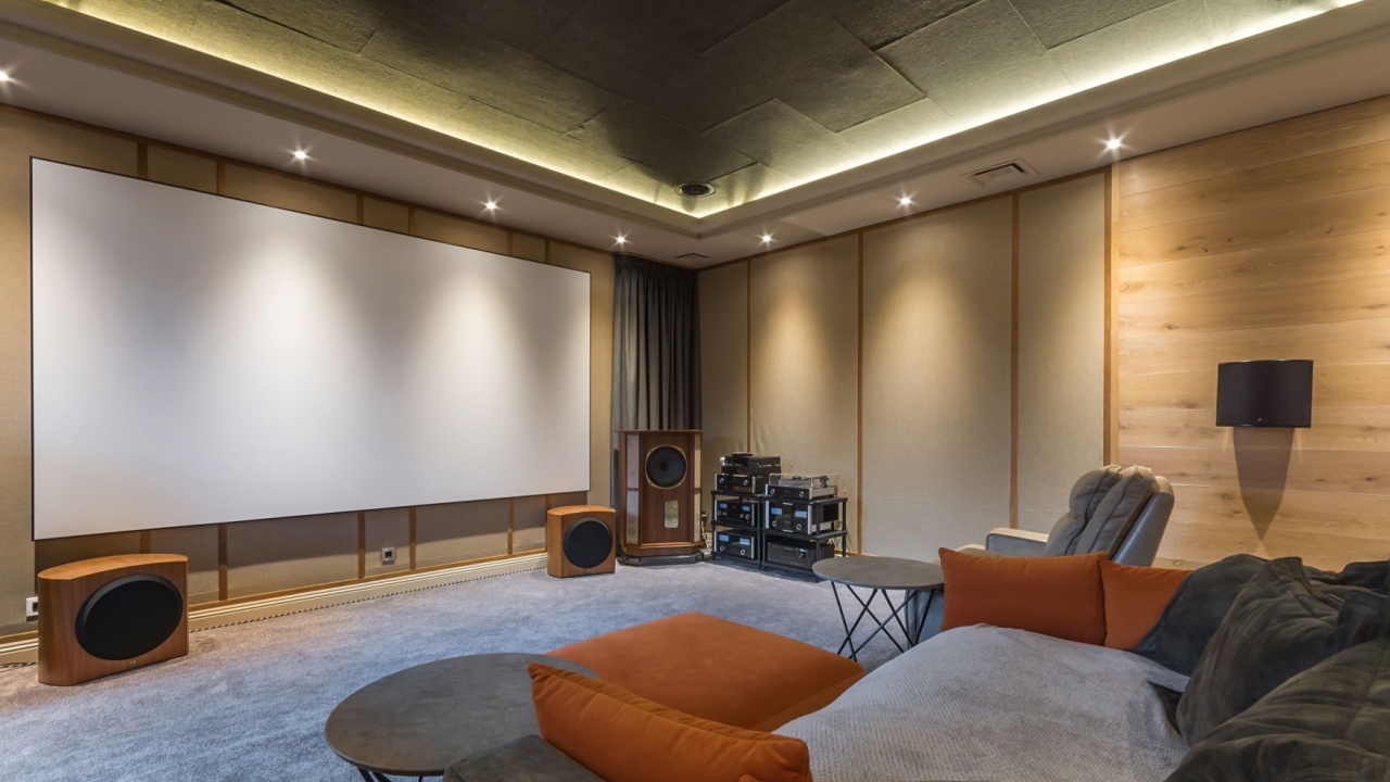 The interior of a home theater with modern equipment. Soft flooring, sofas and armchairs for comfortable viewing.