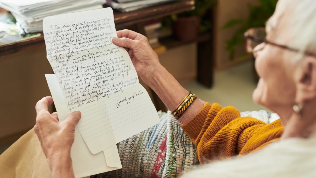 Elderly person reading an intricately handwritten letter, sitting beside a cozy desk filled with stacked papers and plants, expressing emotions of nostalgia and longing while reminiscing