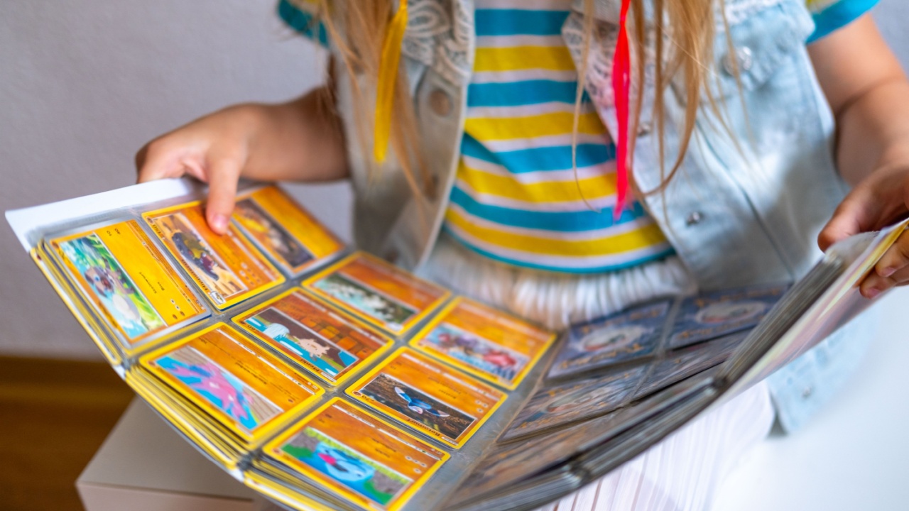 girl collecting Pokemon album, Display various Pokemon cards, popular trading card game for kids, young fans and collectors, Childhood Nostalgia, Frankfurt - May 29, 2025