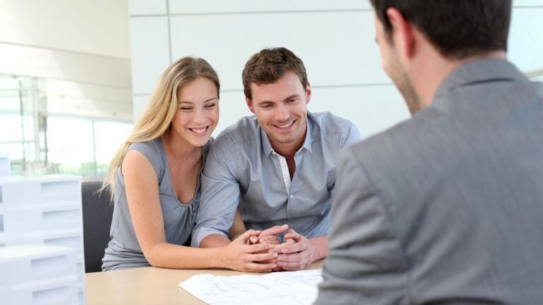 Couple in real-estate agency talking to construction planner