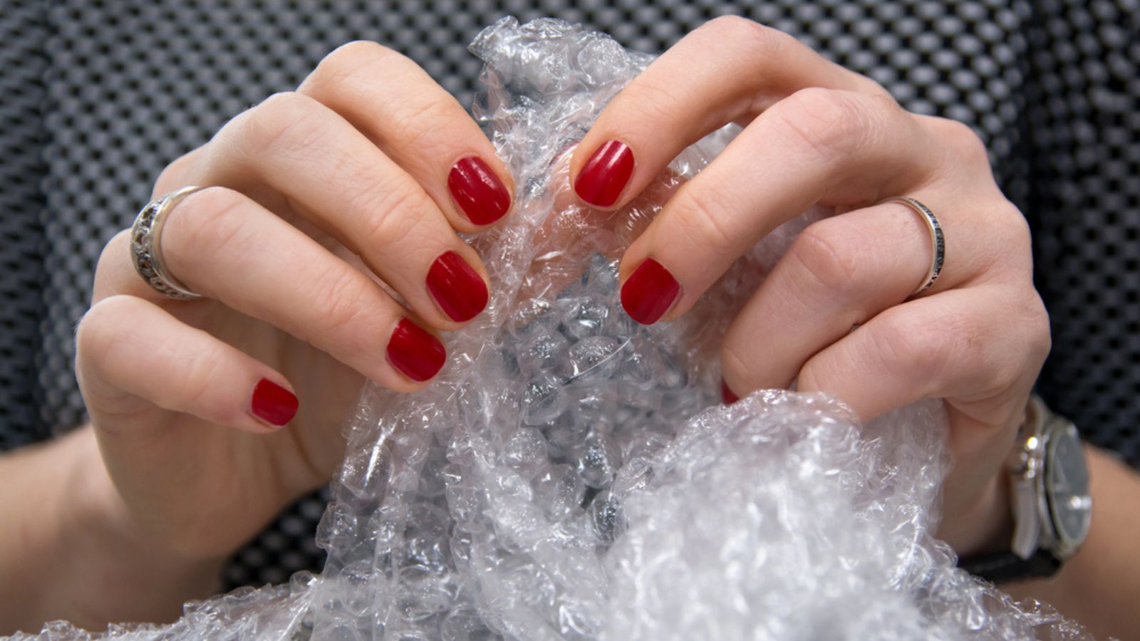 Female hands popping the bubbles in bubble wrap