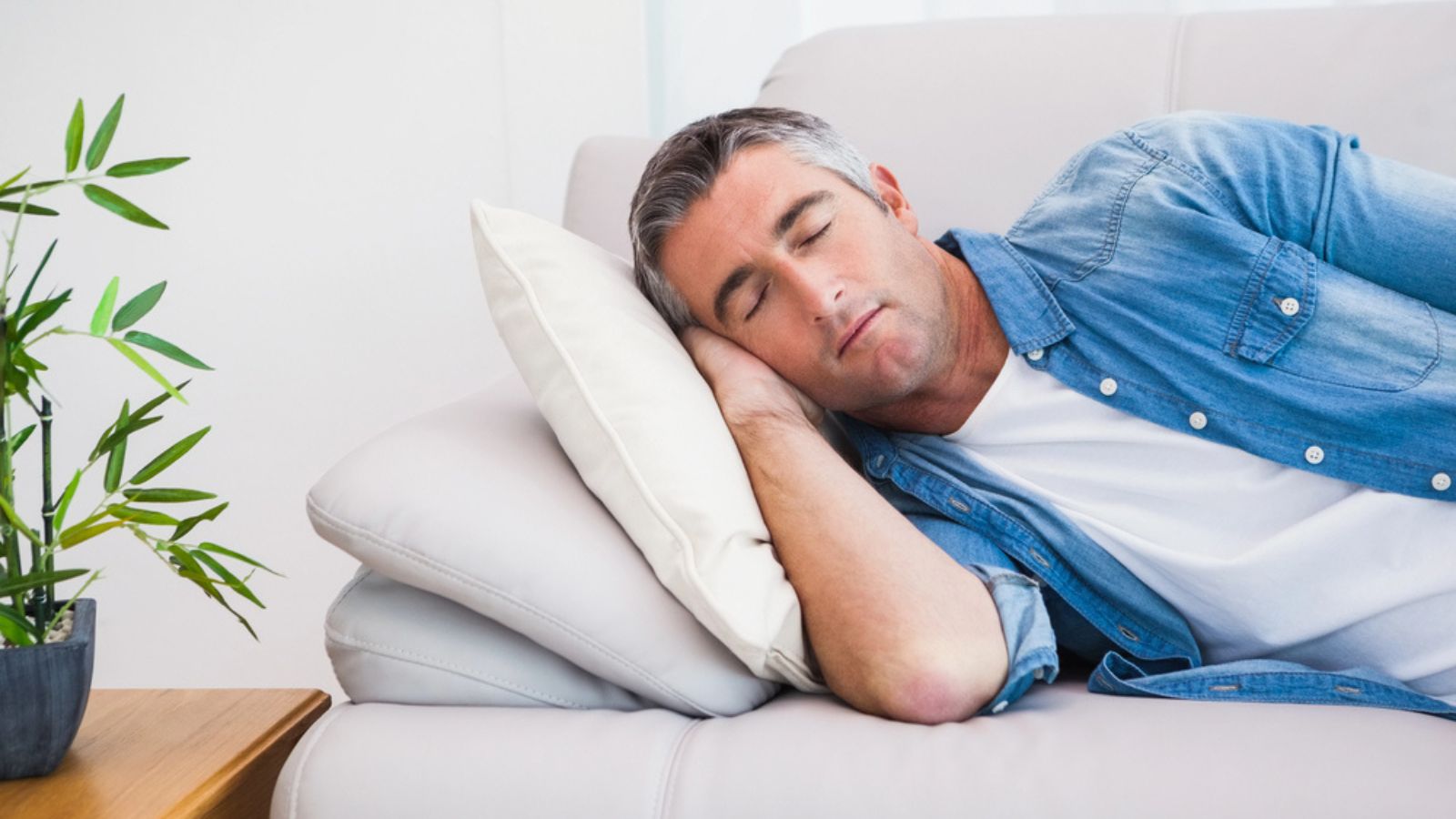 Man with grey hair sleeping on the couch