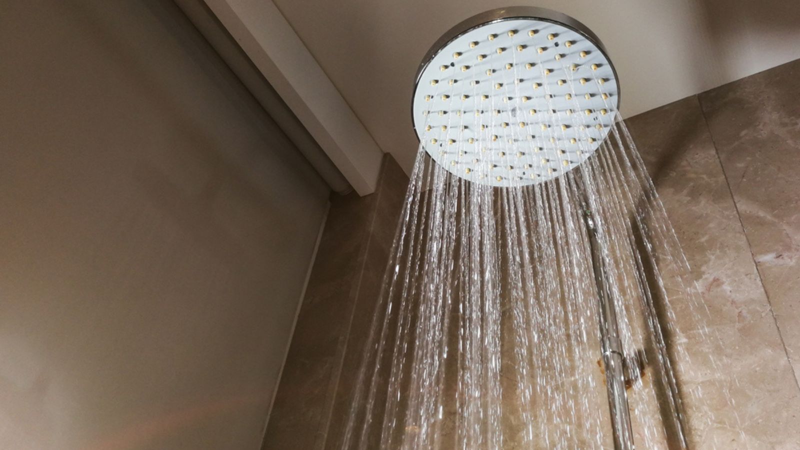 Shower head with refreshing water droplets spraying down in bath