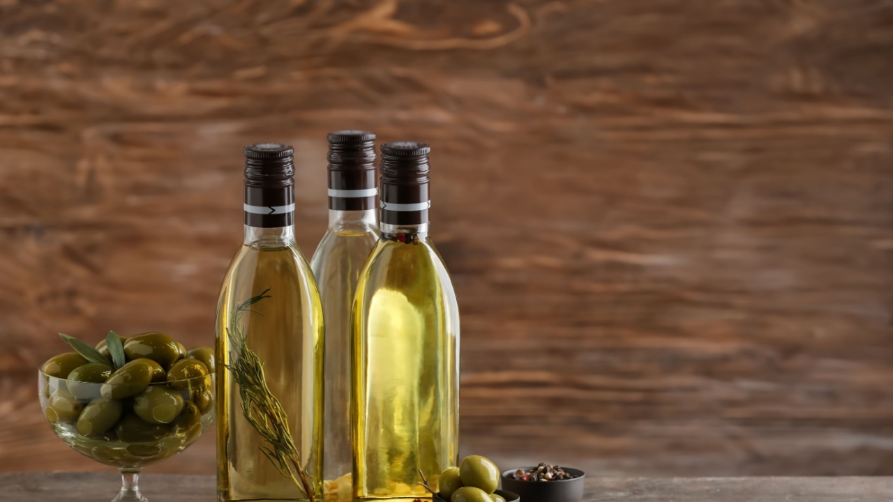 Bottles with olive oil on wooden background