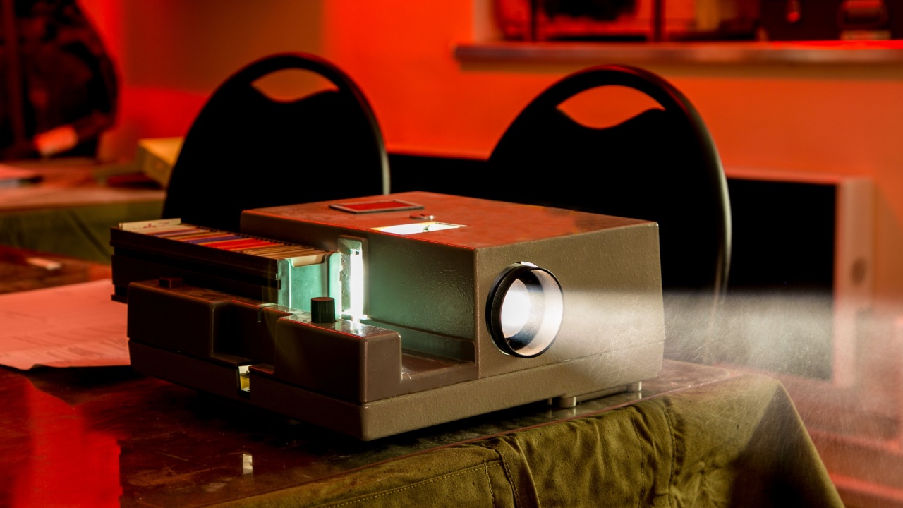 Old vintage slide projector working in dark room.