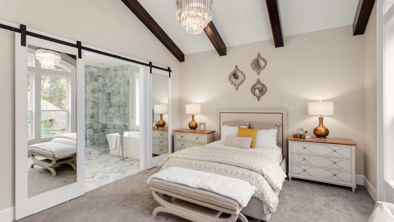 Beautiful Master Bedroom in New Luxury Home with View of Ensuite Bathroom. Features Wood Beams on Ceiling and Sliding Barn Door