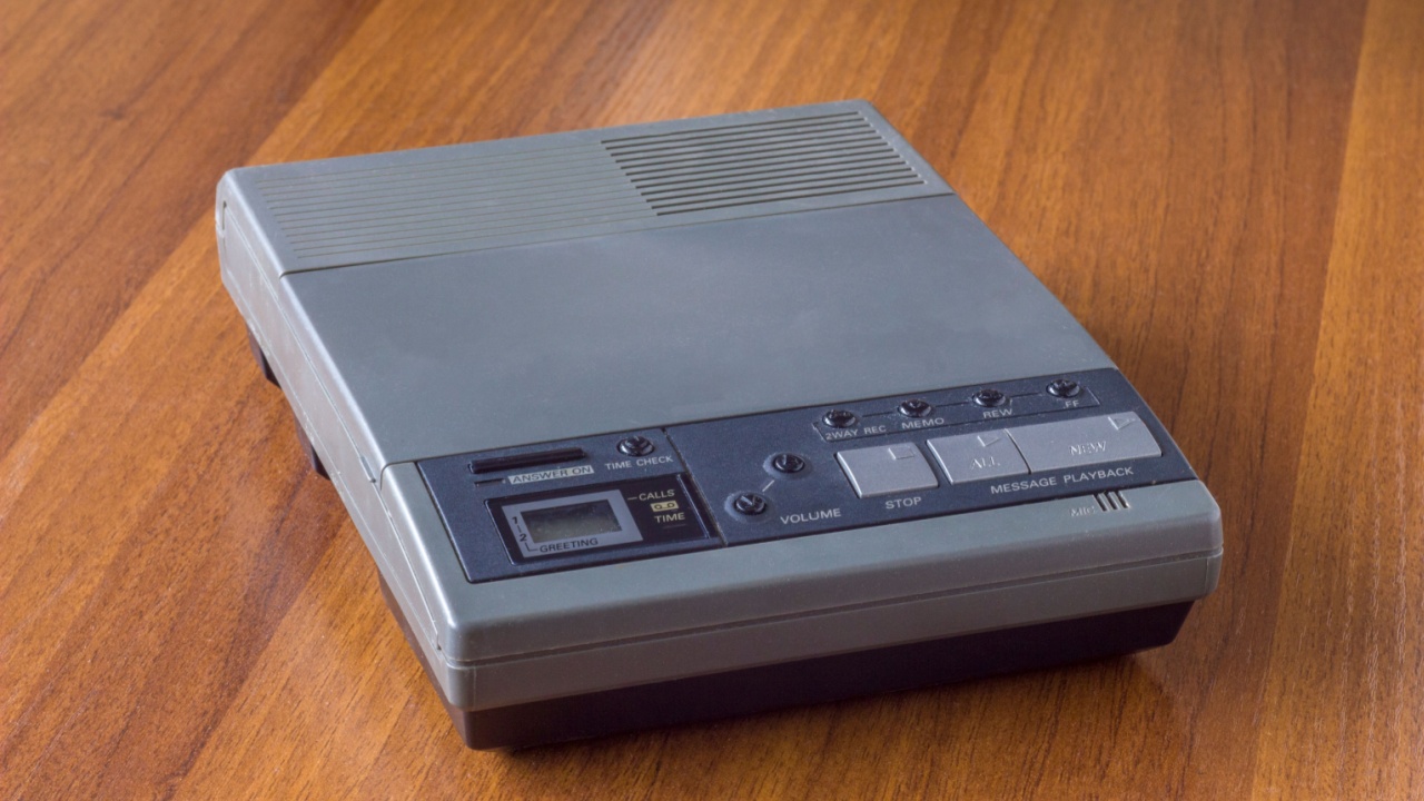 old vintage cassette answering machine on a wooden table surface
