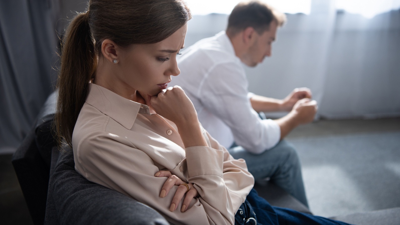 pensive upset couple in living room at home