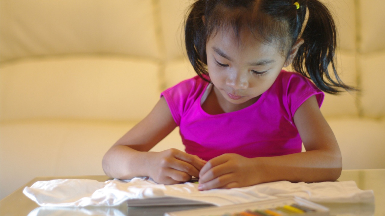 Cute girls are drawing and painting artwork on white fabrics.