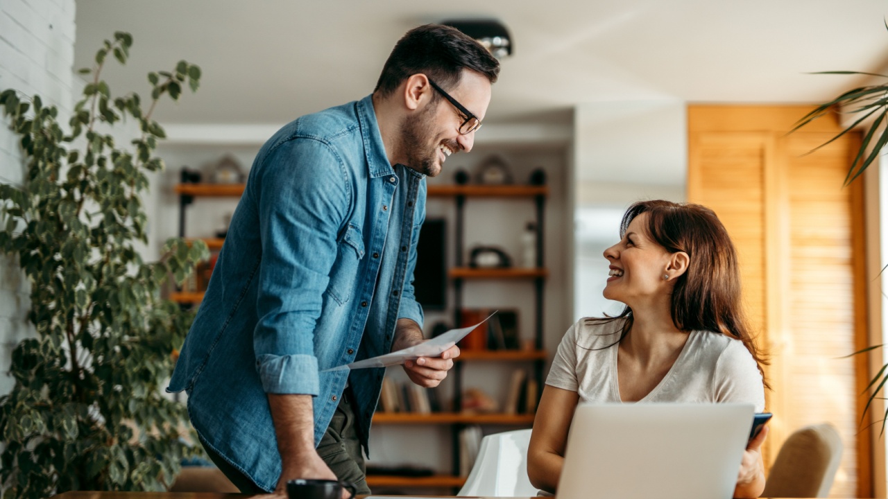 Good news. Couple of smiling coworkers talking.