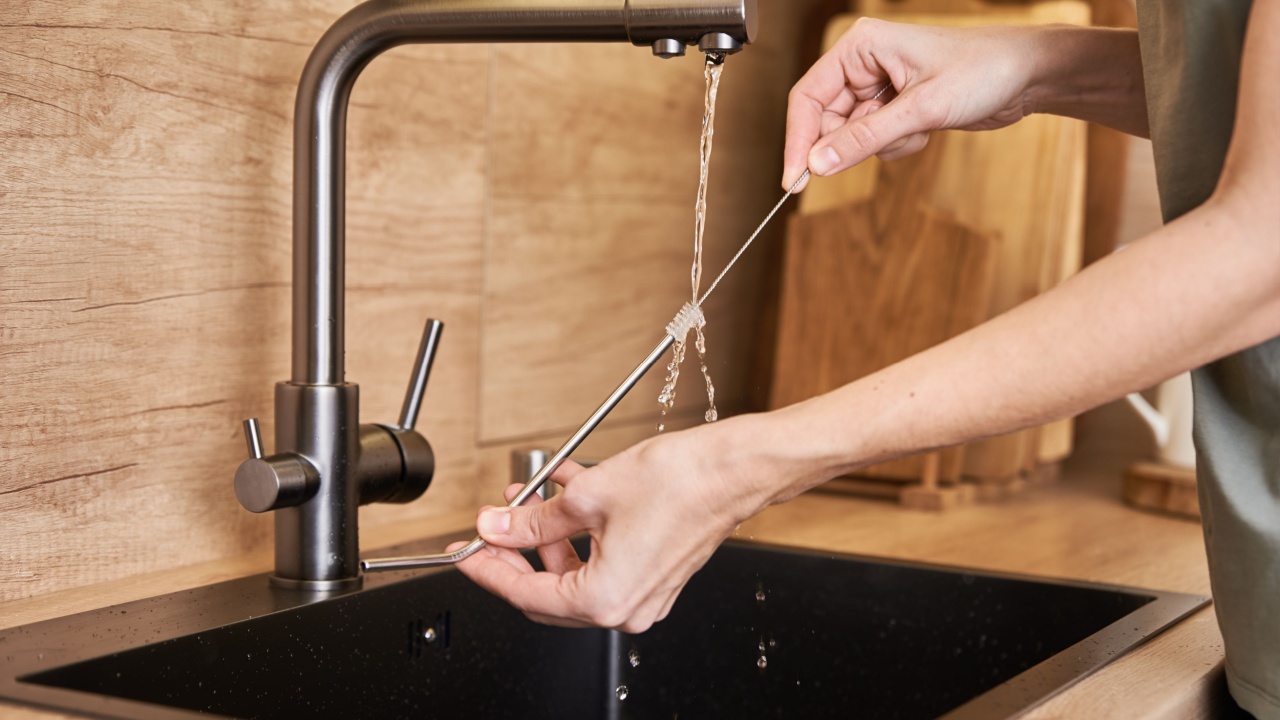 Woman cleaning metal straw with organic brush. Zero waste concept