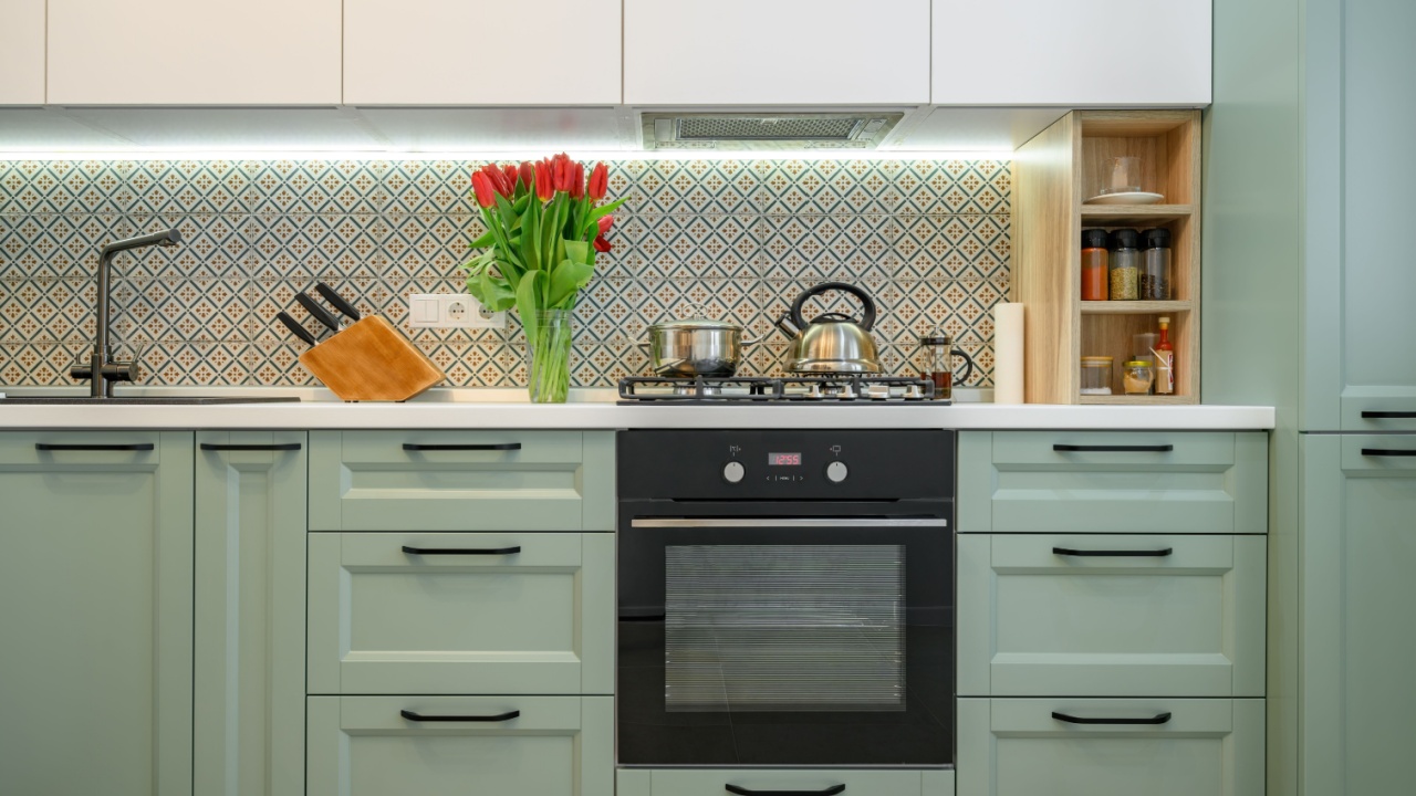 Front view of well designed green-teal and white modern kitchen interior