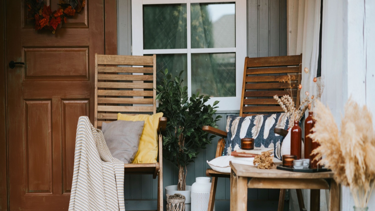 porch of the backyard decorated with pumpkins and dry grass in autumn, rustic furniture on veranda of a rustic house, a cozy and stylish interior in autumn colors