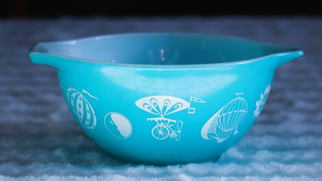 Vintage blue mixing bowl with balloon design, on a white fabric cloth.