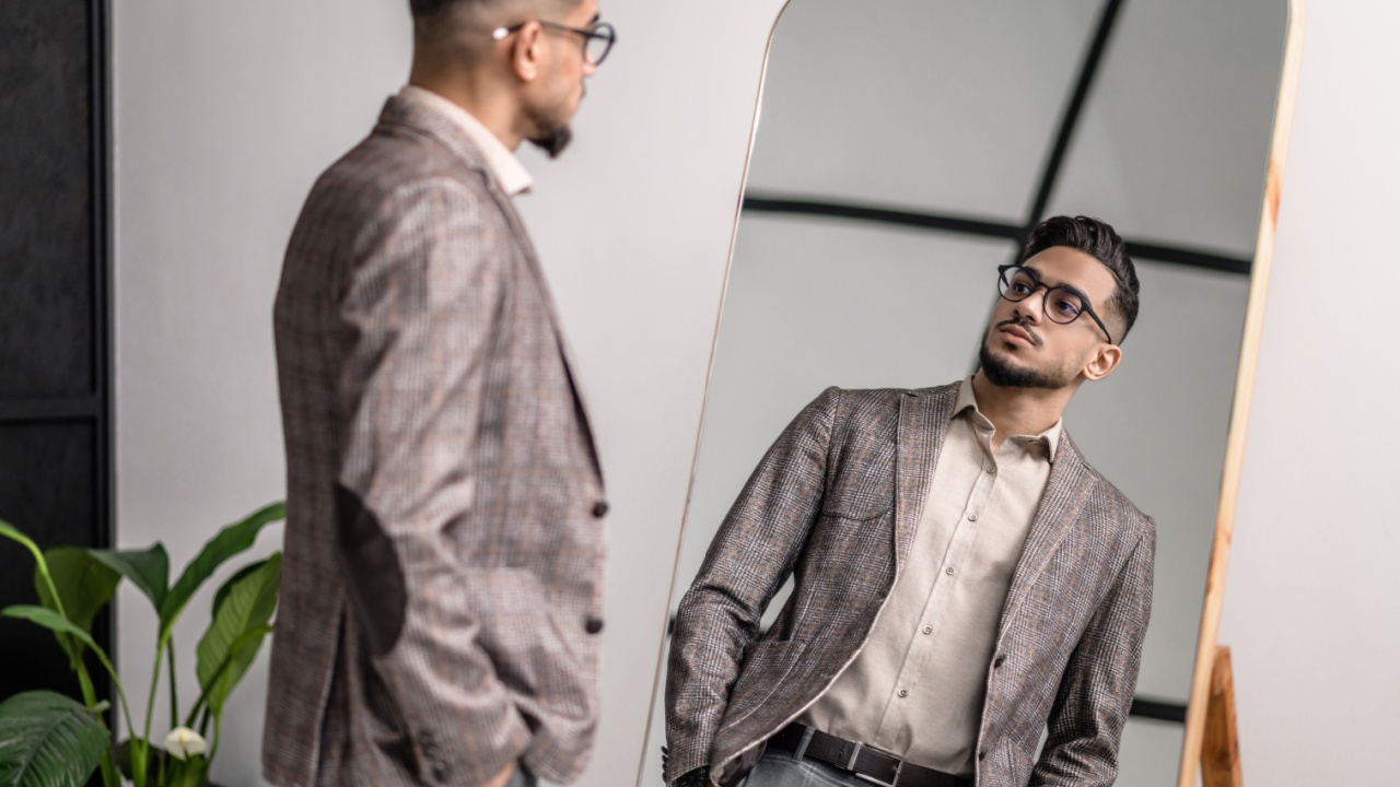 A good-looking young stylish man at the mirror