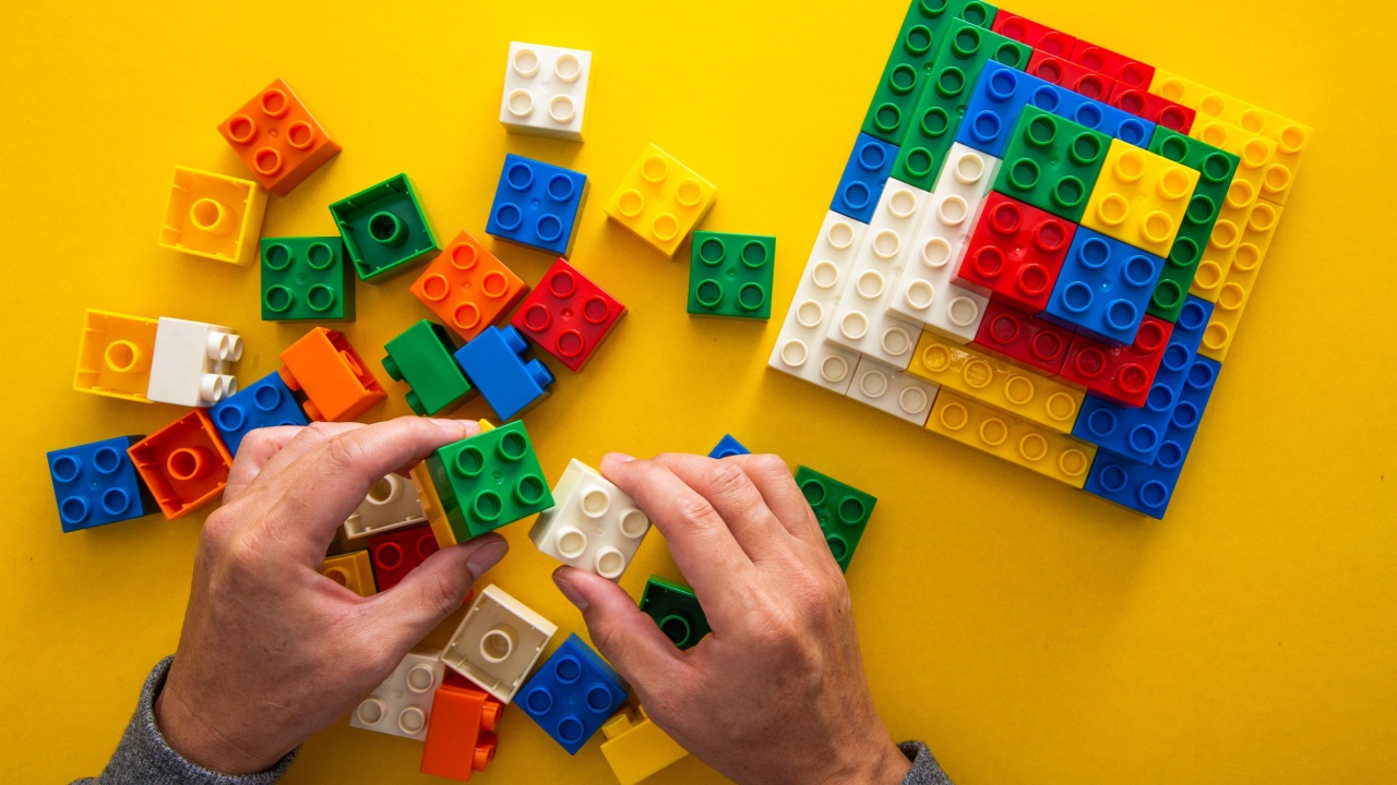hand stacking up the colorful plastic block