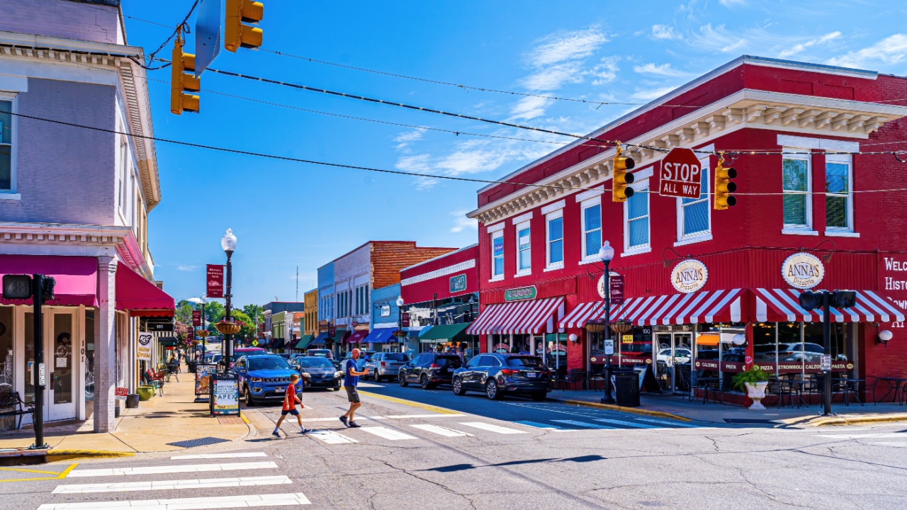Apex, North Carolina USA-07 23 2022: A Man and Boy Cross Main Street in Downtown Apex on a Summer Day.