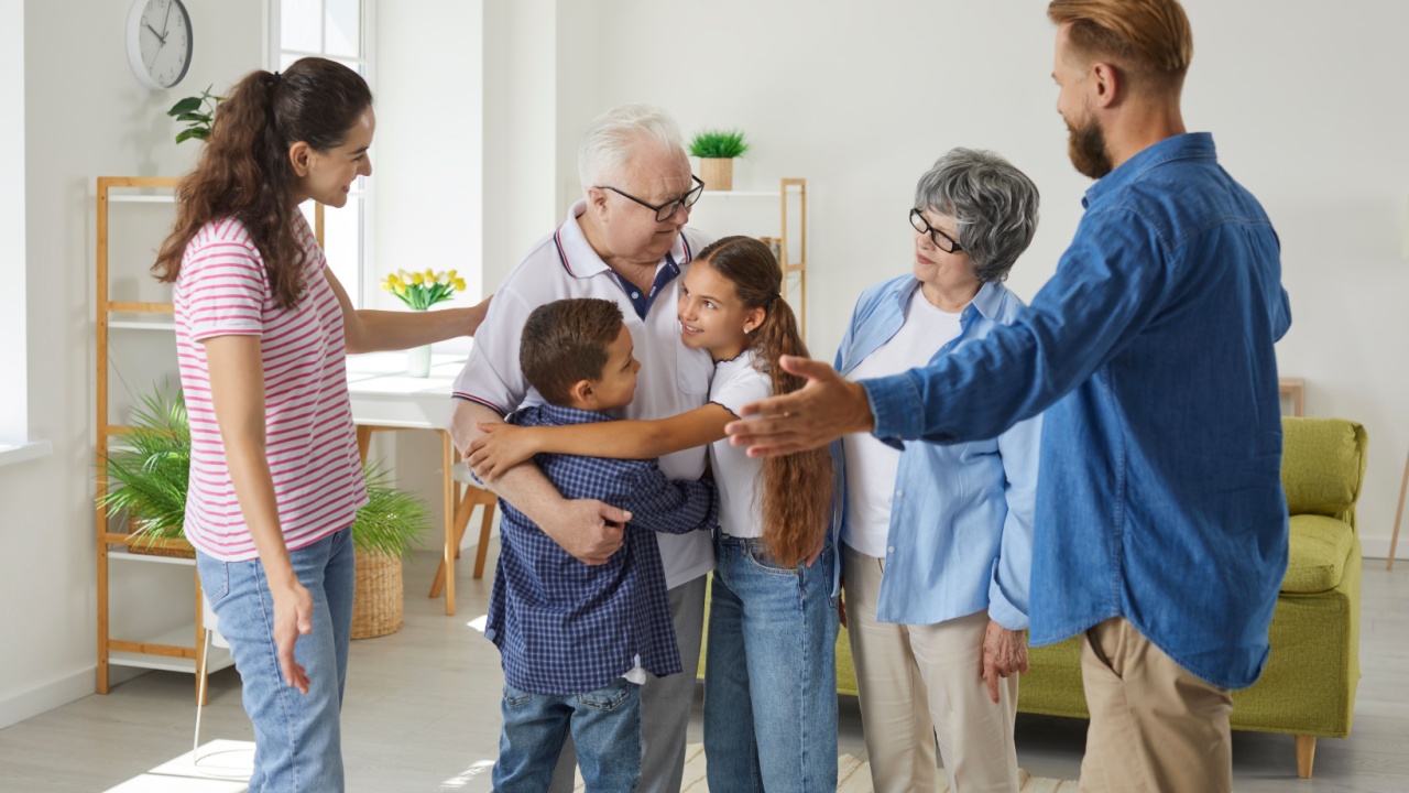 Multigenerational family meet together. Large friendly family meets together on weekends to spend bonding times at home. Young parents, grandparents and grandchildren are hugging together in room.