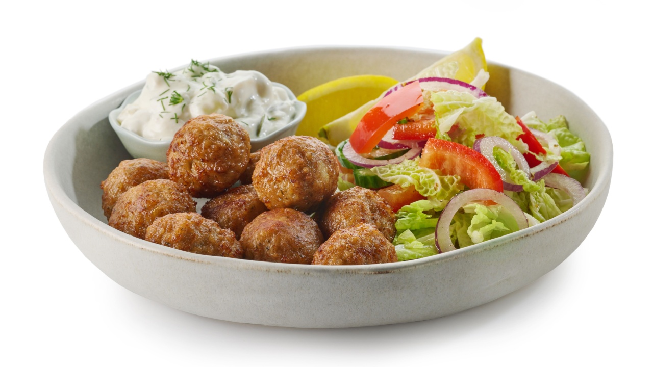 plate of meat balls, vegetable salad and greek tzatziki sauce isolated on white background