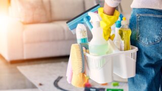 Cleaning, hand and basket of cleaning supplies for family home hygiene with a brush, bottles and gloves. Woman, cleaning supplies and housekeeper about to clean a home for spring cleaning