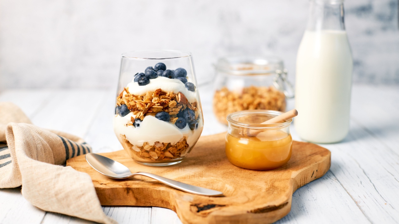 Healthy food concept. Homemade granola with nuts and honey in a glass with yogurt and fresh berries for breakfast. Vegetarian food.